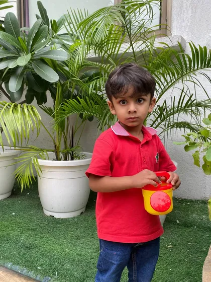 This young boy takes his responsibility of watering the plants very seriously. It's a calming and rewarding activity that connects children to the natural world.