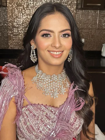 A close-up of her reception makeup. The look features a shimmery pink eyeshadow, glowing skin, and a natural pink lip.
