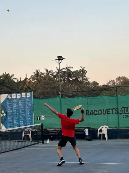 Precision in every swing, power in every serve. A TenniStation player demonstrates a powerful overhead smash during a practice session.