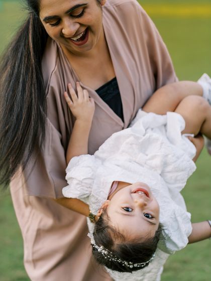 A mother swinging her daughter around, both laughing. The movement and joy make this a dynamic and happy photo.