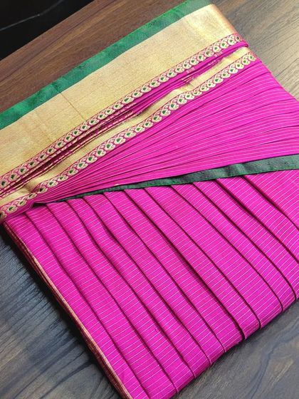 A bright pink saree with a gold border, neatly box-folded. This method is ideal for storing sarees for long periods, as it minimizes stress on the fabric.