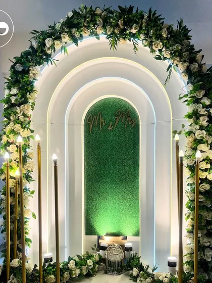 Simple, elegant, and full of romance. This 'Mr & Mrs' arch, framed with white roses and lit by glowing candles, is perfect for an intimate anniversary or engagement, proving that even small spaces can be transformed into a magical setting.