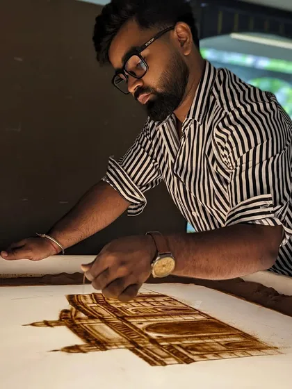 A shot of me working on the Lodha Group sand art, carefully adding details to the architecture.