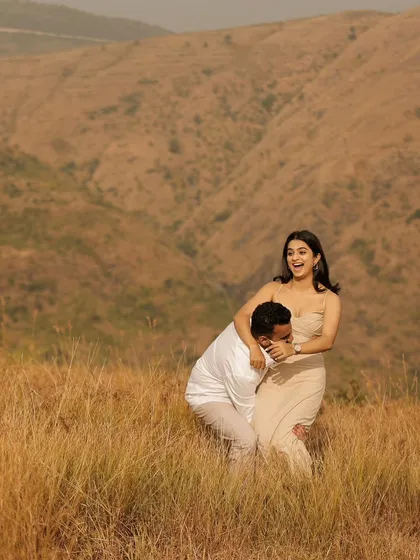 A moment of pure, uninhibited laughter and joy in the middle of a golden field. This candid shot perfectly captures the couple's fun-loving spirit.