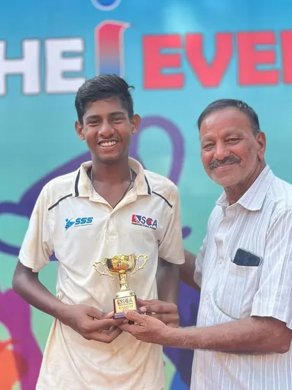 A smiling player from the runners-up team with his trophy.
