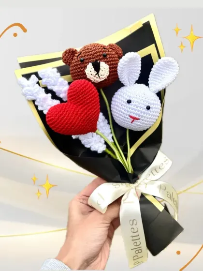 A close-up of our adorable character bouquet, featuring a teddy bear, bunny, and heart. The craftsmanship in each crochet figure is on full display.