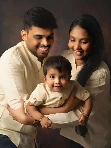 A joyful family moment, perfectly framed. The coordinated neutral outfits and classic studio lighting create a warm, painterly portrait that feels both timeless and full of life.