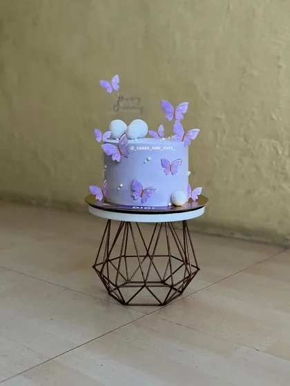 A beautiful purple butterfly cake with pearl details, perfect for a girl's birthday.
