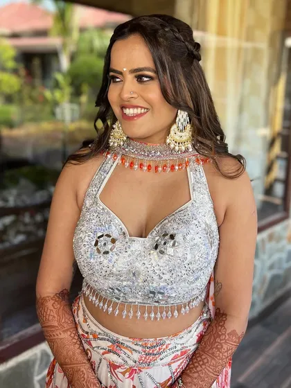 A happy bride at her Mehendi/Haldi, her makeup is dewy with bold, defined eyes.