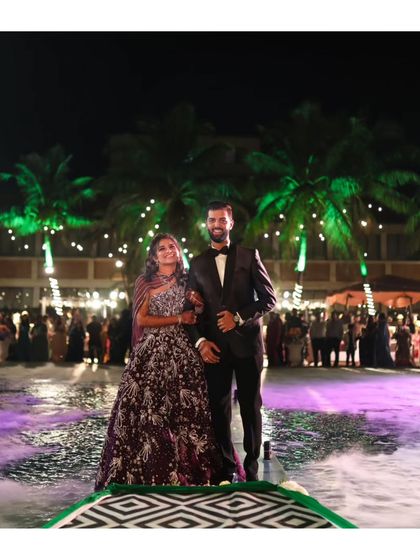 The couple's grand entrance over a pool at their reception. The combination of water, smoke, and dramatic lighting makes for a stunning and unique visual.