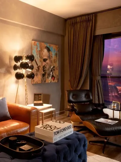 The den at sunset, showing how the moody lighting and rich textures create a warm and intimate ambiance. The iconic "Godfather" artwork adds to the room's character.