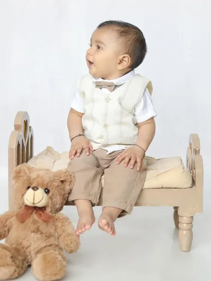 A happy boy on his little bed. Using baby-sized furniture helps to create adorable and perfectly scaled scenes.