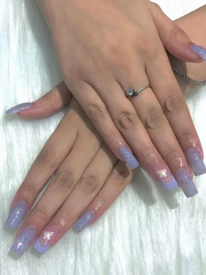 The long, square shape of these nails provides a great canvas for the glitter and butterfly art.