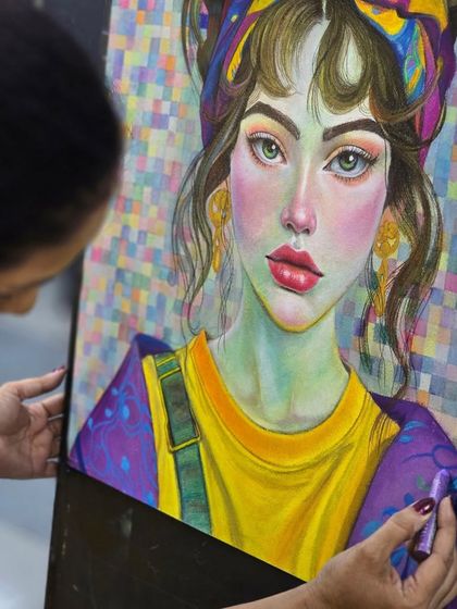 A close-up shot of the artist's hand as she blends colors on the portrait, demonstrating the tactile nature of working with oil pastels.