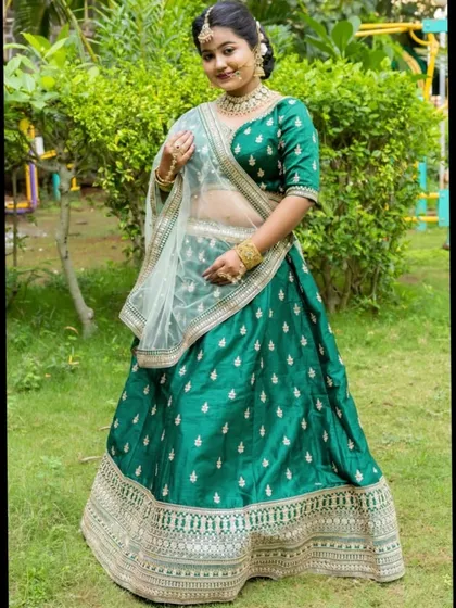 Another beautiful shot of the emerald green lehenga, paired with a sheer white dupatta that provides a lovely contrast.