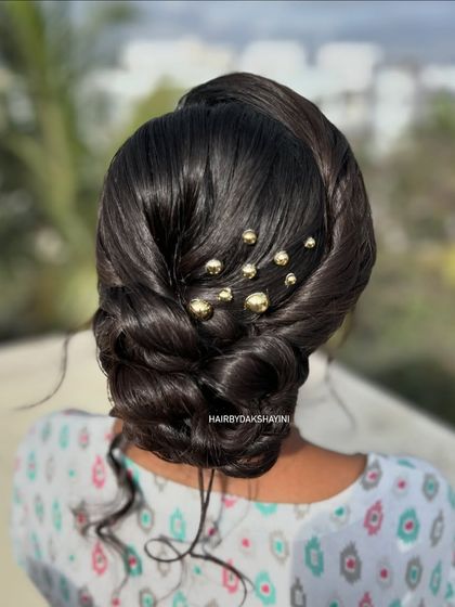 A clear back view of the textured low bun with scattered gold beads, a chic and modern accessory choice.