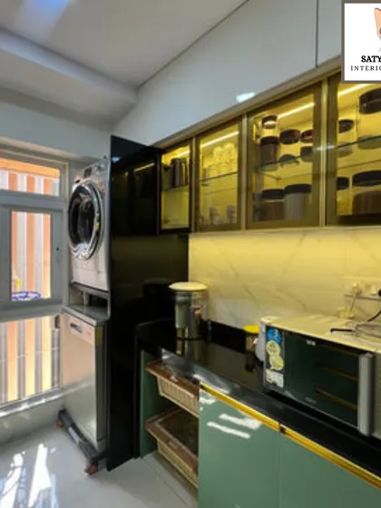 A highly functional utility area within the kitchen, with stacked laundry appliances and illuminated glass cabinets for storage.