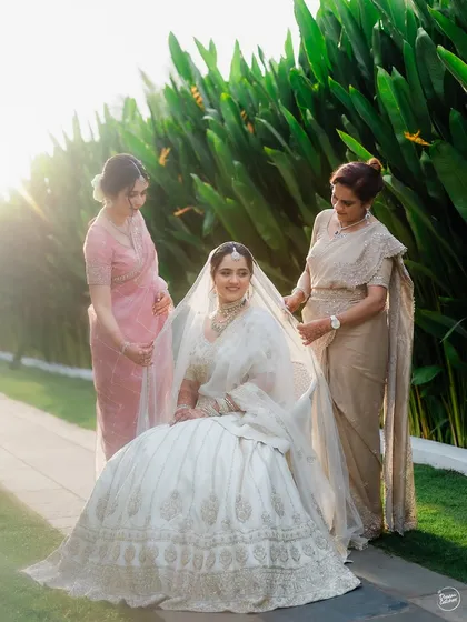 A precious moment as the bride's mother and sister help her with her veil. A beautiful portrait of three generations.