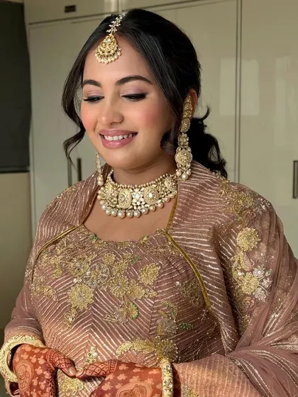 The little one is on the way, and mom-to-be Ayushi is glowing. We went for a traditional look with a beautiful maang tikka and a soft, peachy makeup palette.