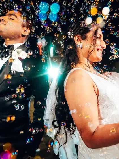 A magical moment captured amidst a shower of bubbles. The joy on their faces is completely real, creating a dynamic and celebratory portrait that feels full of life.