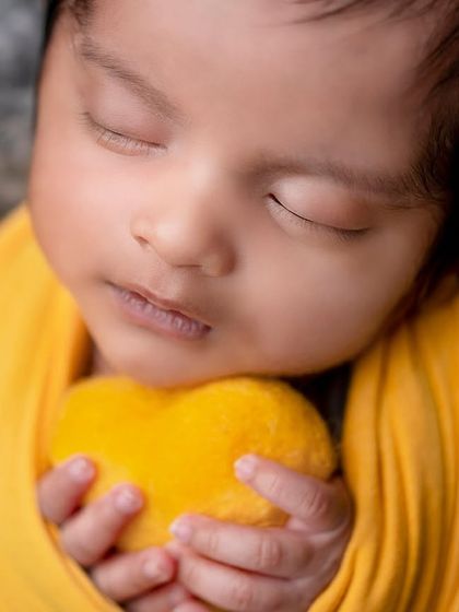 A duplicate of image 205, a heartwarming portrait of a newborn holding a heart.