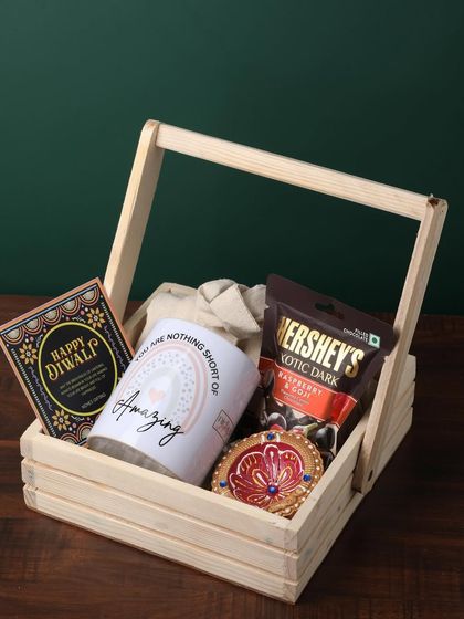 This wooden basket hamper is a lovely gesture of appreciation. It contains a "You are nothing short of Amazing" mug, a pack of Hershey's dark chocolate, and a decorative diya.