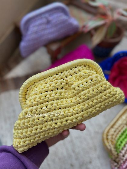 A bright yellow handmade clutch. This piece is crafted from t-shirt yarn, giving it a unique texture and sturdiness while remaining lightweight.