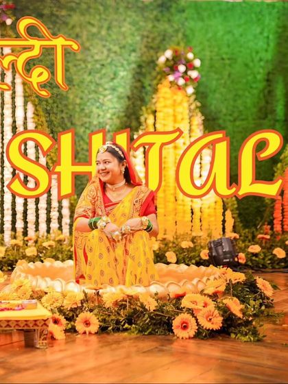 A portrait of the bride, Shital, seated amidst a beautiful floral Haldi setup. This showcases the decor and the bride's happy anticipation.