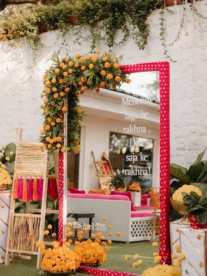 We love adding personalized elements. This custom mirror for a Mehandi event, framed with polka-dot fabric and marigolds, featured a classic Bollywood song lyric to set the mood.