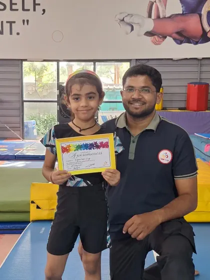 This student is all smiles after receiving her certificate from our head coach.