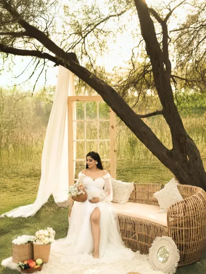 Another beautiful portrait from the boho-chic setup, this shot captures the mother-to-be looking down at her bouquet, surrounded by earthy tones and natural textures.