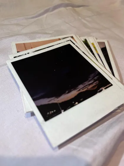 A stack of thick Polaroids, with a moody night sky photo on top. This highlights the rich, deep colors my printing process can achieve, even for low-light images.