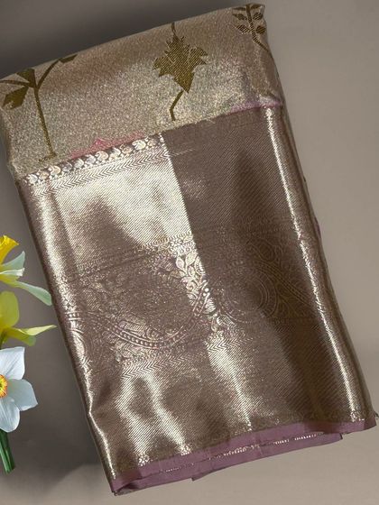 A close-up of a gold tissue Kanchi silk saree with leaf motifs.