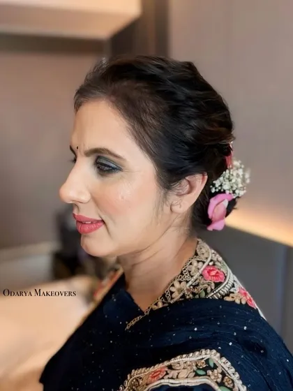 A side profile of this heavy glam look, showing the elegant floral bun and the flawless skin.