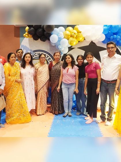 A lovely group photo of the family at the Manchester-themed party, celebrating together.