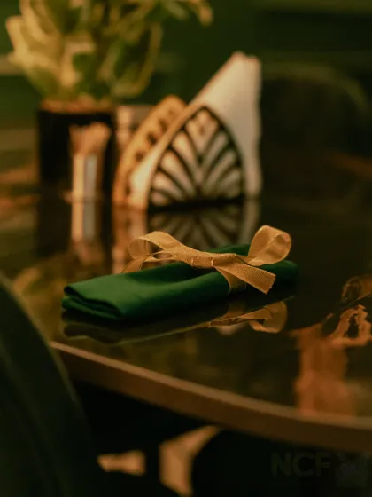 A close-up of the table setting, with a neatly folded napkin tied with a golden ribbon. I believe in paying attention to the small details.