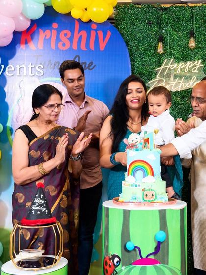 Capturing the cake cutting moment at a fun Cocomelon party.