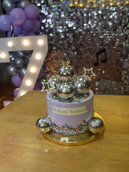 The disco cake in front of the sparkling backdrop. We pay close attention to every visual element to create a cohesive and beautiful party setup.