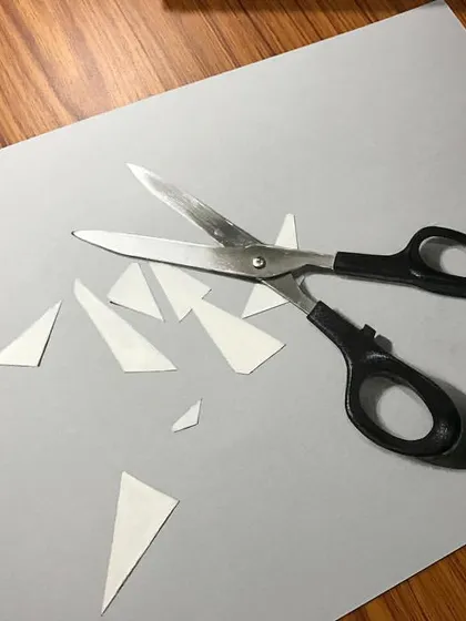 A realistic drawing of scissors cutting paper. This piece plays with the illusion of one drawing interacting with the paper it's drawn on.