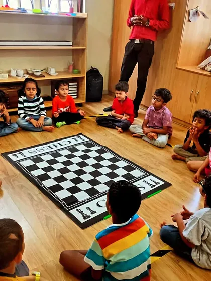 A moment of calm before the game begins. In our group classes, we guide students through simple mindfulness exercises. This helps them clear their minds, sharpen their focus, and prepare for strategic thinking around our large floor chessboard.