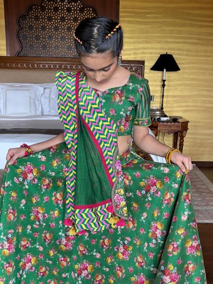 The young client looking down, showing off her beautiful traditional outfit and the intricate hairstyle that completes the look.