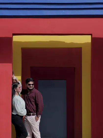 A couple poses for their pre-wedding shoot against our vibrant, geometric-patterned colorful wall, ideal for modern and artistic portraits.