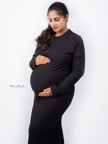 A simple yet powerful portrait in a classic black dress against a clean white background. This minimalist style truly highlights the beauty of the baby bump.