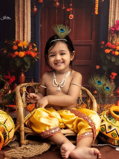 A happy 'Kanha' sitting in a wicker chair. The joy on his face is infectious, making this a perfect portrait to celebrate Krishna's birth.