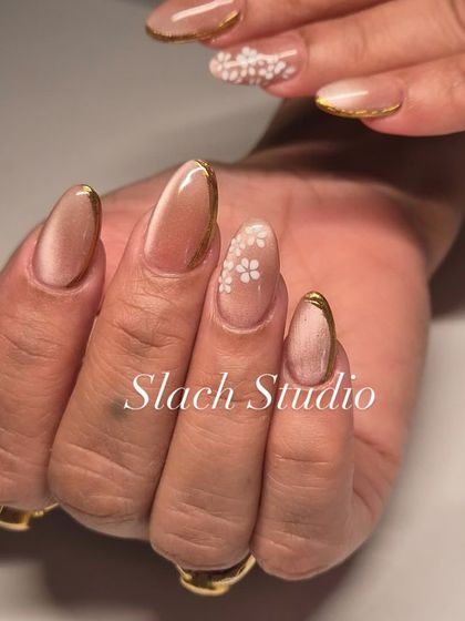 A different view of the nude cat-eye nail set, showing how the light plays on the magnetic polish. The combination of the gold trim and floral art is subtle yet stunning.