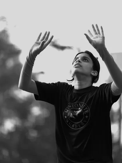 A player reaches for the sky, hands ready to set the ball. This black and white shot emphasizes the form and aspiration of the action.