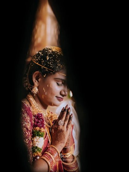 An artistic portrait of the bride in prayer, her face partially obscured, creating a sense of intimacy and reverence.