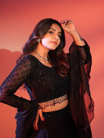 A close-up shot of the black lehenga, showing the detailed sequin work on the blouse and the delicate fringed hem.