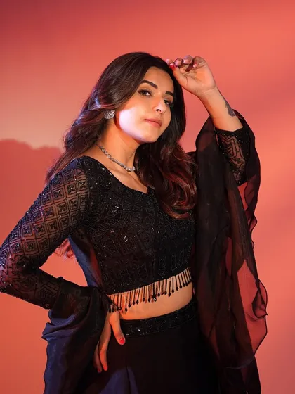 A close-up shot of the black lehenga, showing the detailed sequin work on the blouse and the delicate fringed hem.