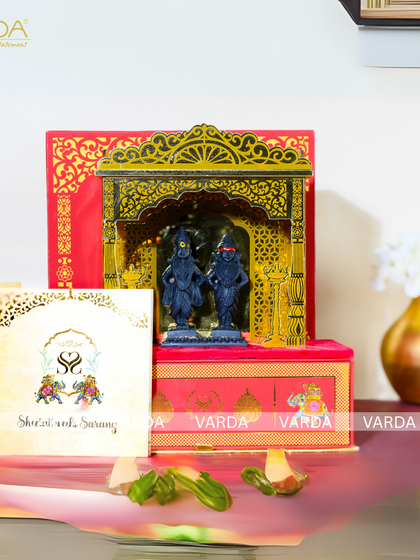 A divine wedding invitation featuring a 3D temple arch with idols of Shri Vitthal and Rukmini. The red and gold box is adorned with floral motifs and comes with a personalized invitation card, perfect for a traditional Maharashtrian wedding.